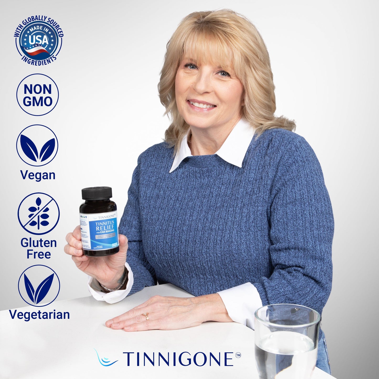 A woman smiling and holding a Tinnigone bottle